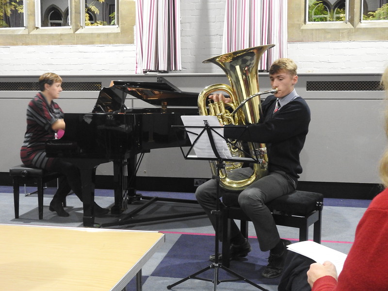 Boy playing tuba accompanied by pianist