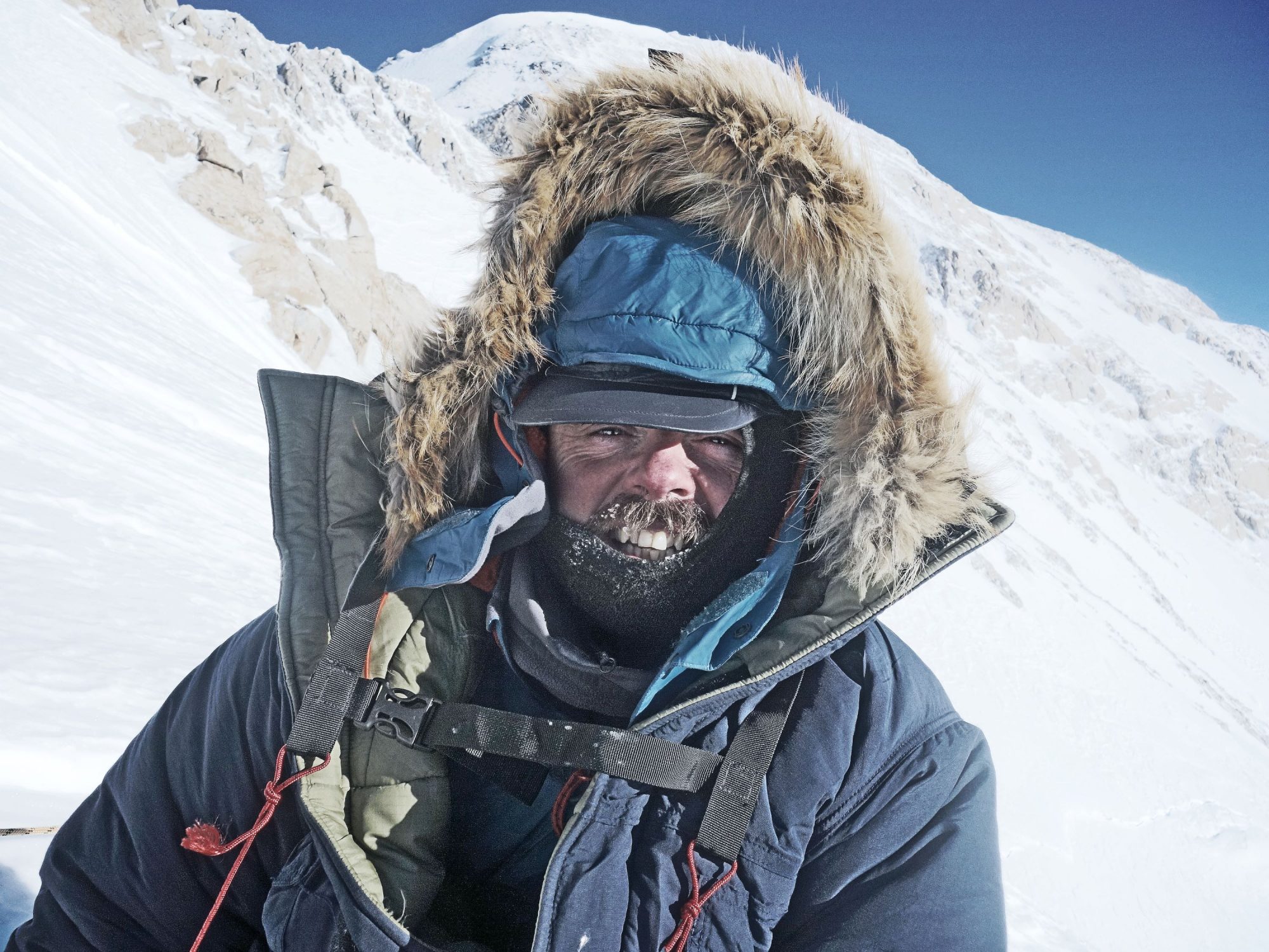 Kirkpatrick in a fur-lined hood with a snowy mountain background