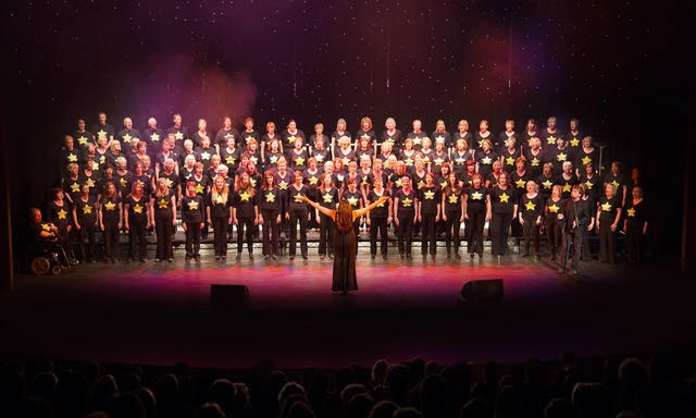 A big choir standing on stage singing