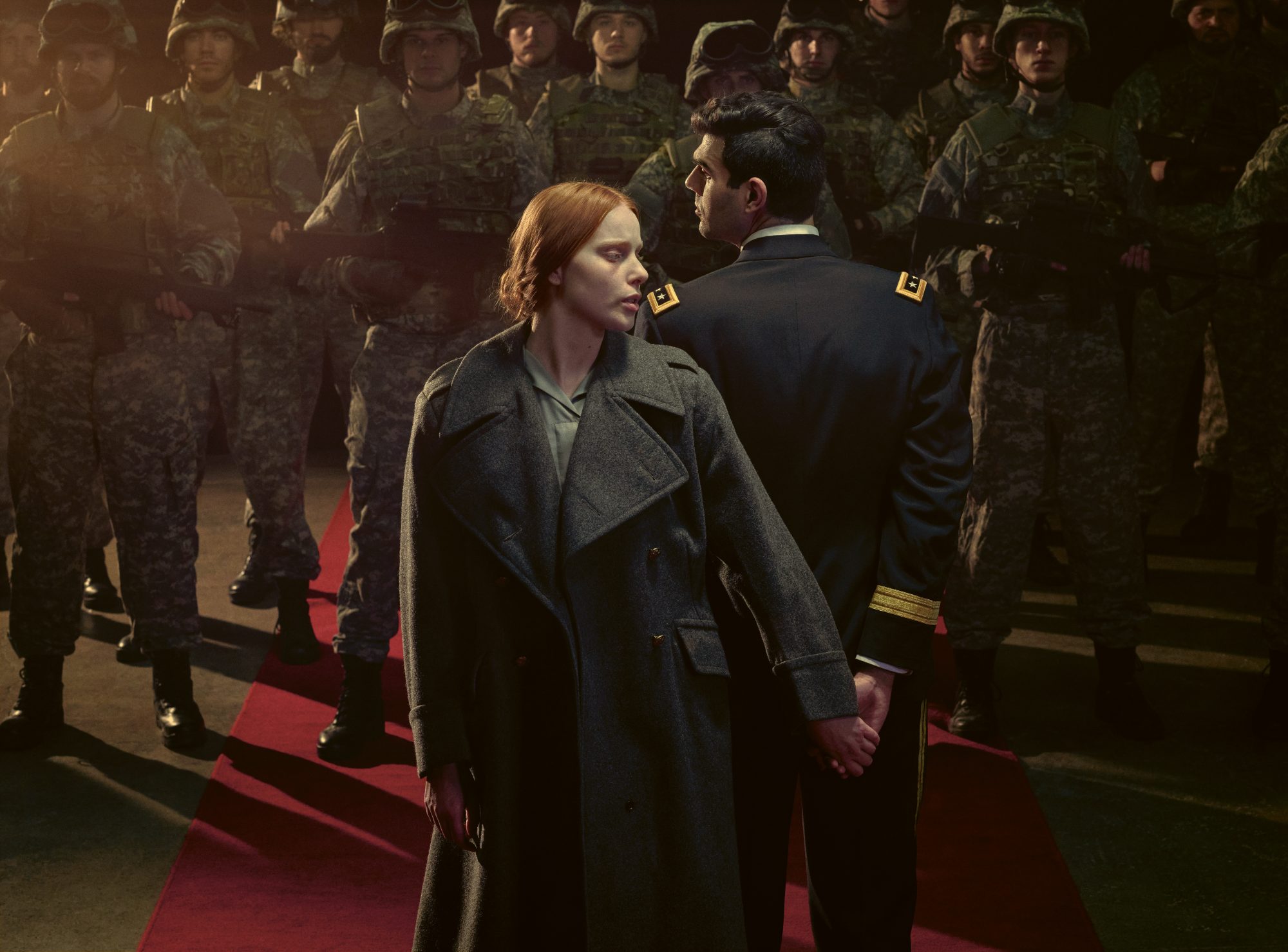 A man and a woman stand back to back in front of a group of strangers