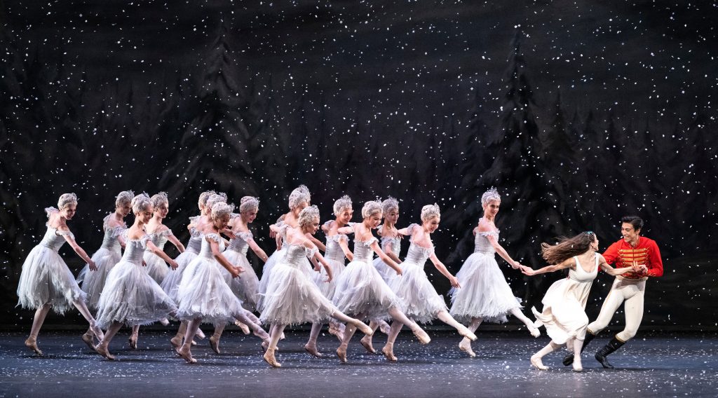 Women in white dresses dancing on stage