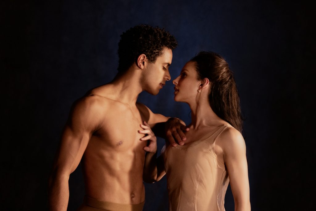 A man and a woman face-to-face touching each other's chests