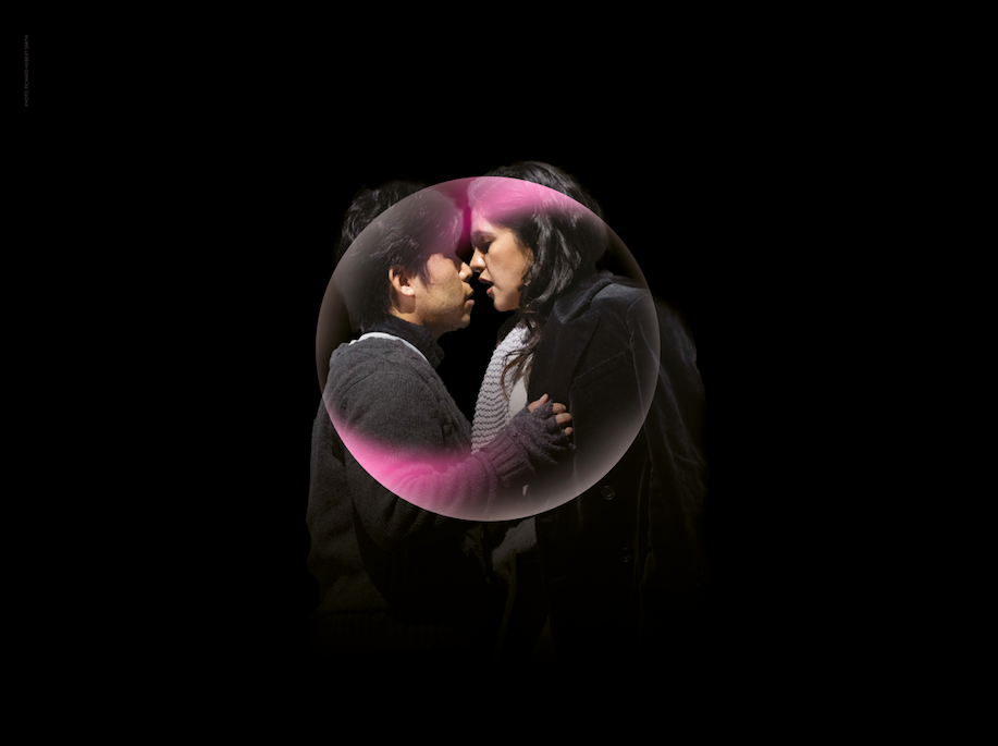 A man and a woman with their faces close together, with a bubble in front of them