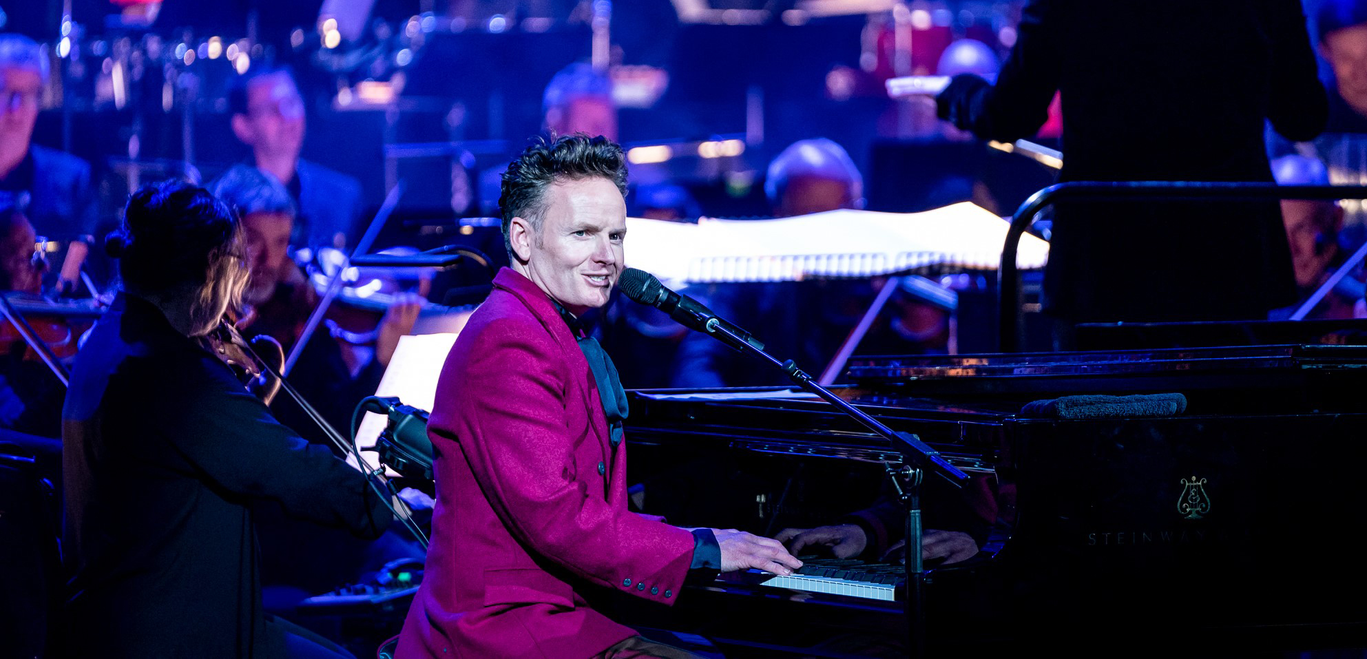 Joe Stilgoe playing and singing at a grand piano