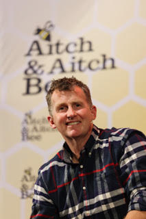 Photo of Nigel Owens in plaid shirt