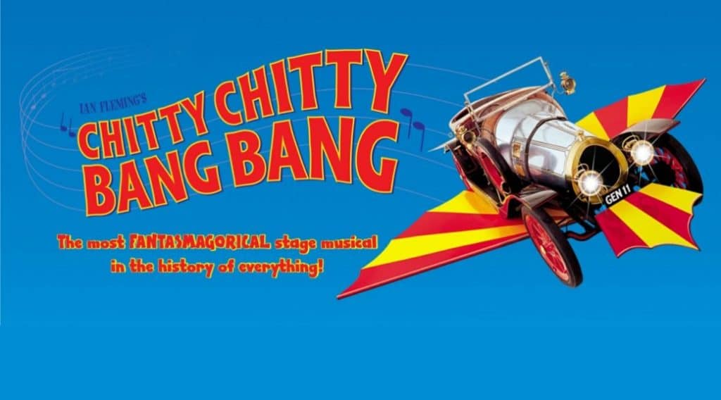 The Chitty car flying across a bright blue background with red and yellow wings.