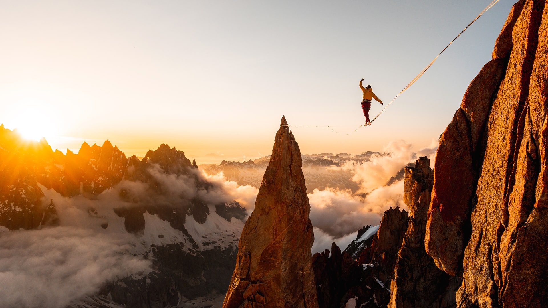 A figure walks across a tightrope, seemingly in mid-air in a mountain landscape. Picture by Antoine Mesnage