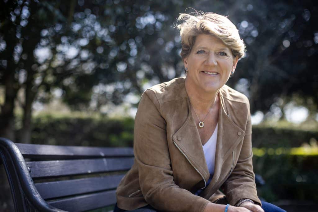 Clare Balding sitting on a park bench