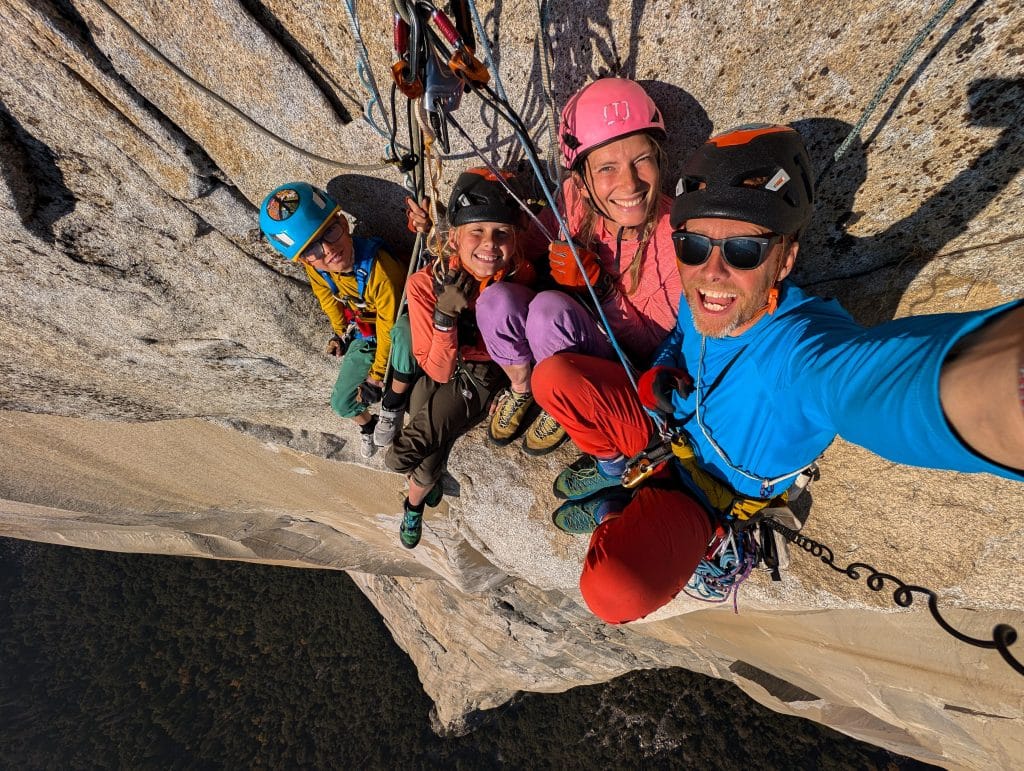 A group of four climbers on a cliff face