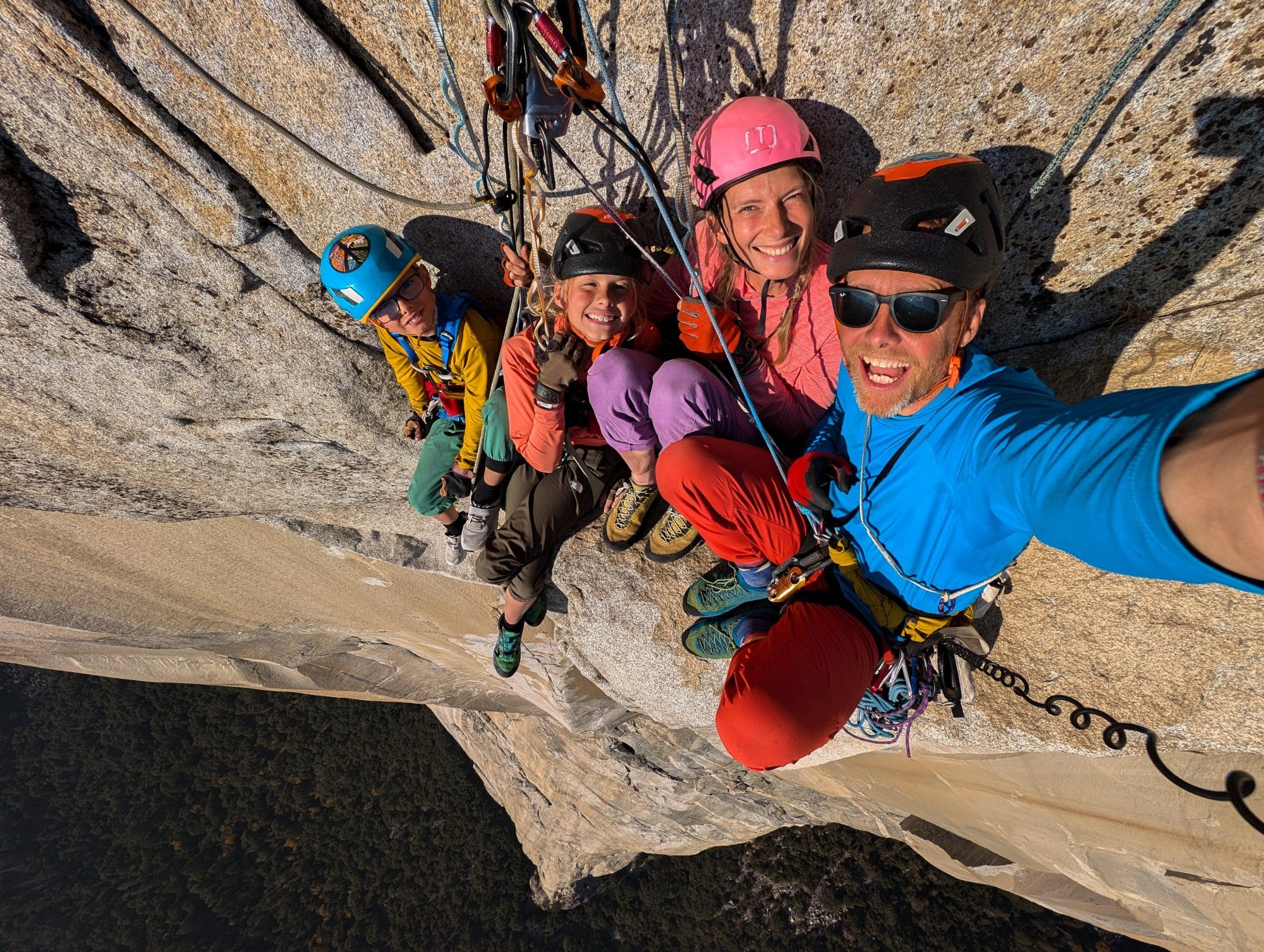 A group of four climbers on a cliff face